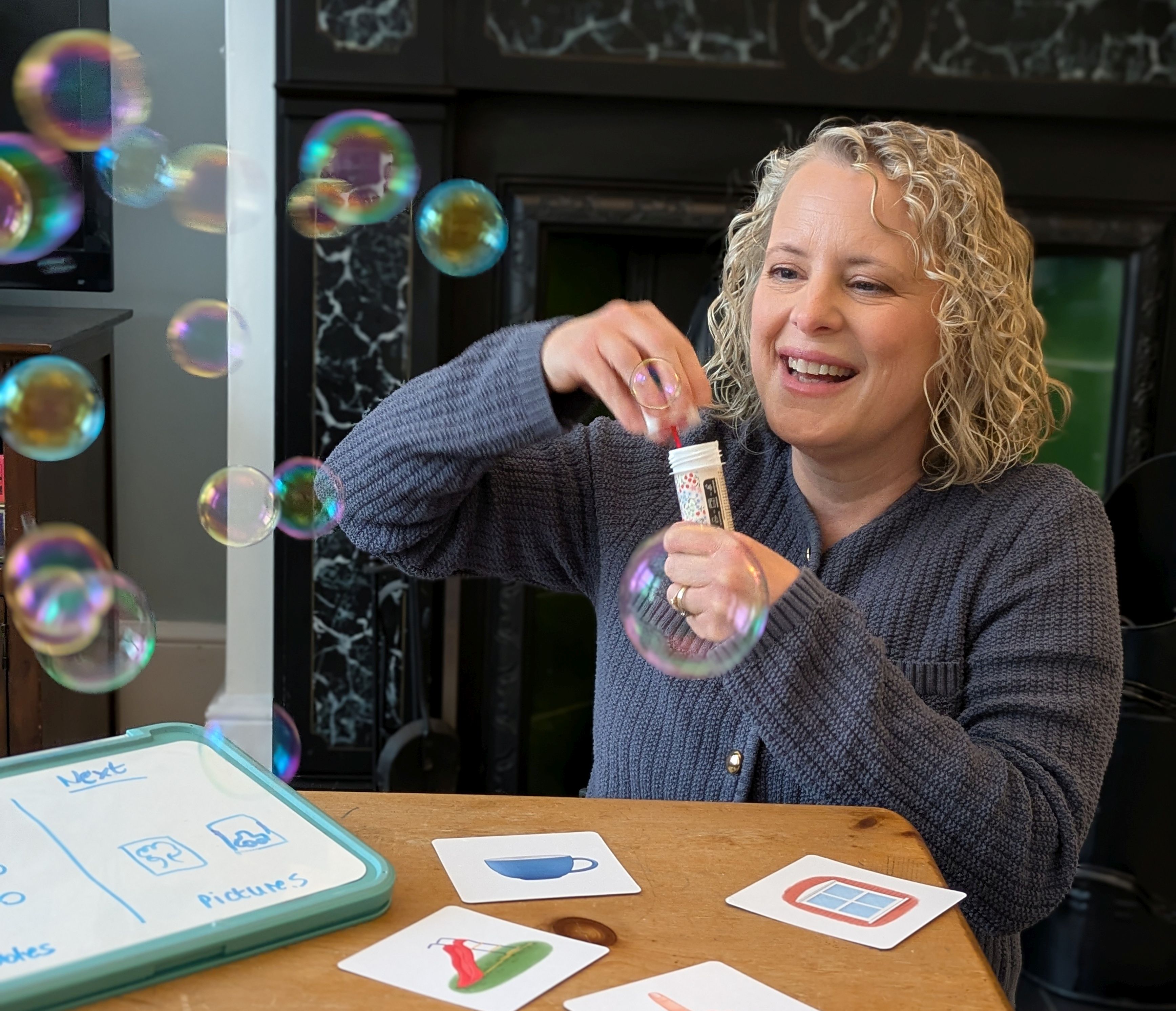 Photo of Kate blowing bubbles in speech therapy session with child (not shown in image)